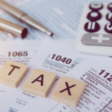 Tax season with wooden alphabet blocks, calculator, pen on 1040