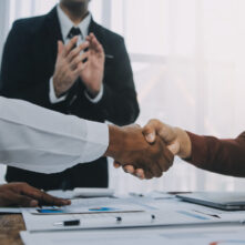 Real estate agent and customers shaking hands together celebrating finished contract after about home insurance and investment loan, handshake and successful deal.